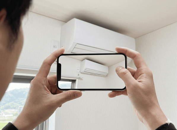 エアコン設置場所をスマホで撮影している様子